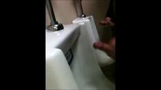 two slim dicks getting wanked at the urinals